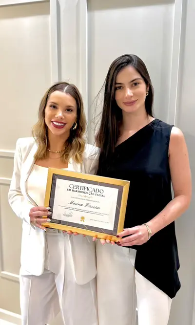 A Dra. Mariane Felin entrega o certificado da mentoria à Dra. Marina Ferreira